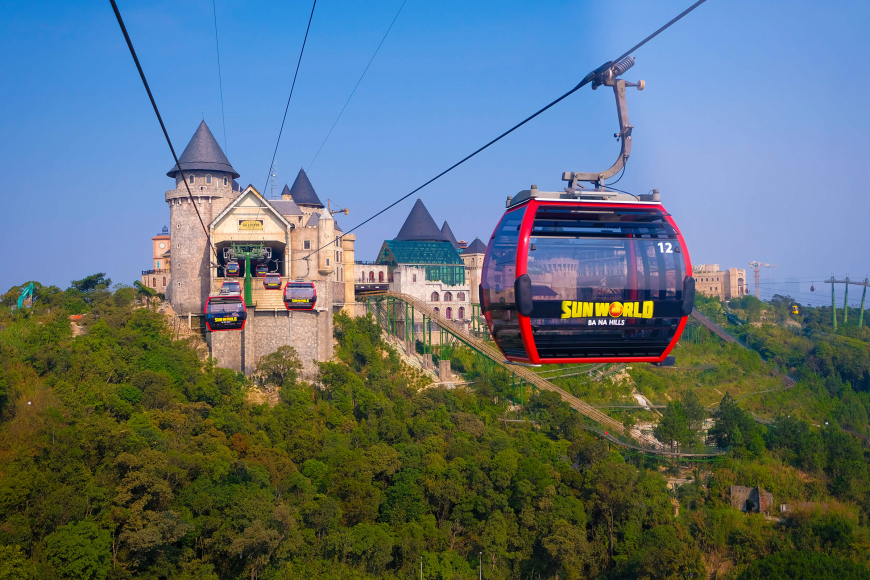 Cable car arriving at the Ba Na Hills French Village station above the forested mountainside