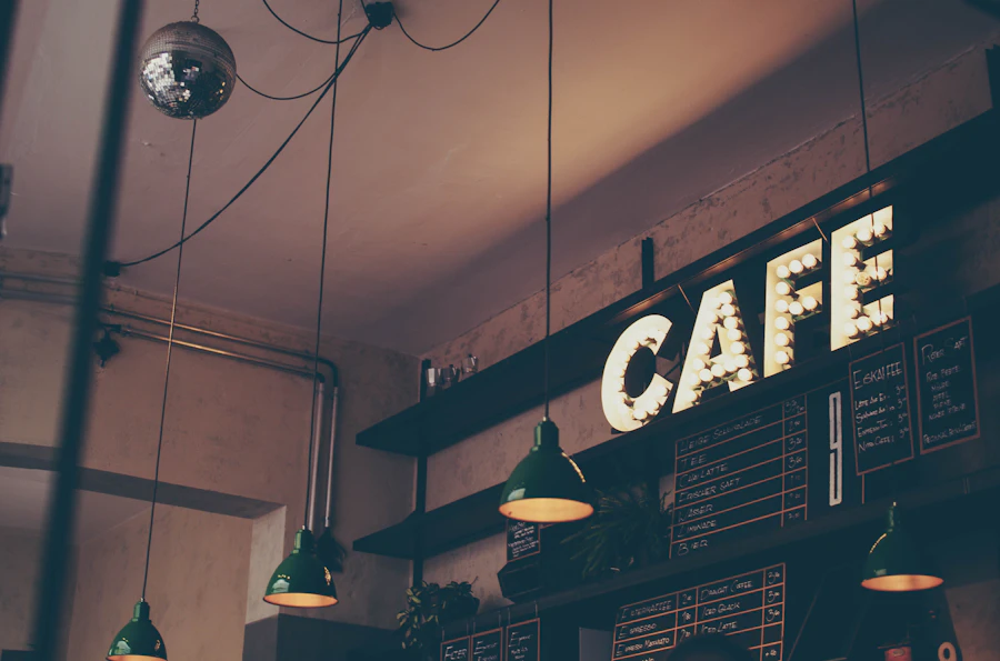 Cafe interior with illuminated CAFE sign, pendant lights and workspace seating