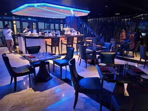 The Horizon Bar at Four Points by Sheraton Danang at night, with bar seating and a lit bar counter