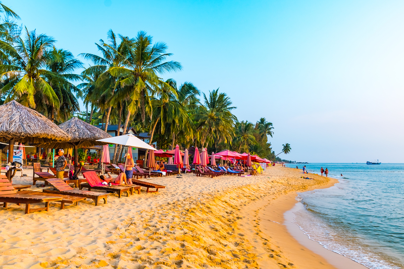 Phu Quoc tropical beach with palm trees and loungers