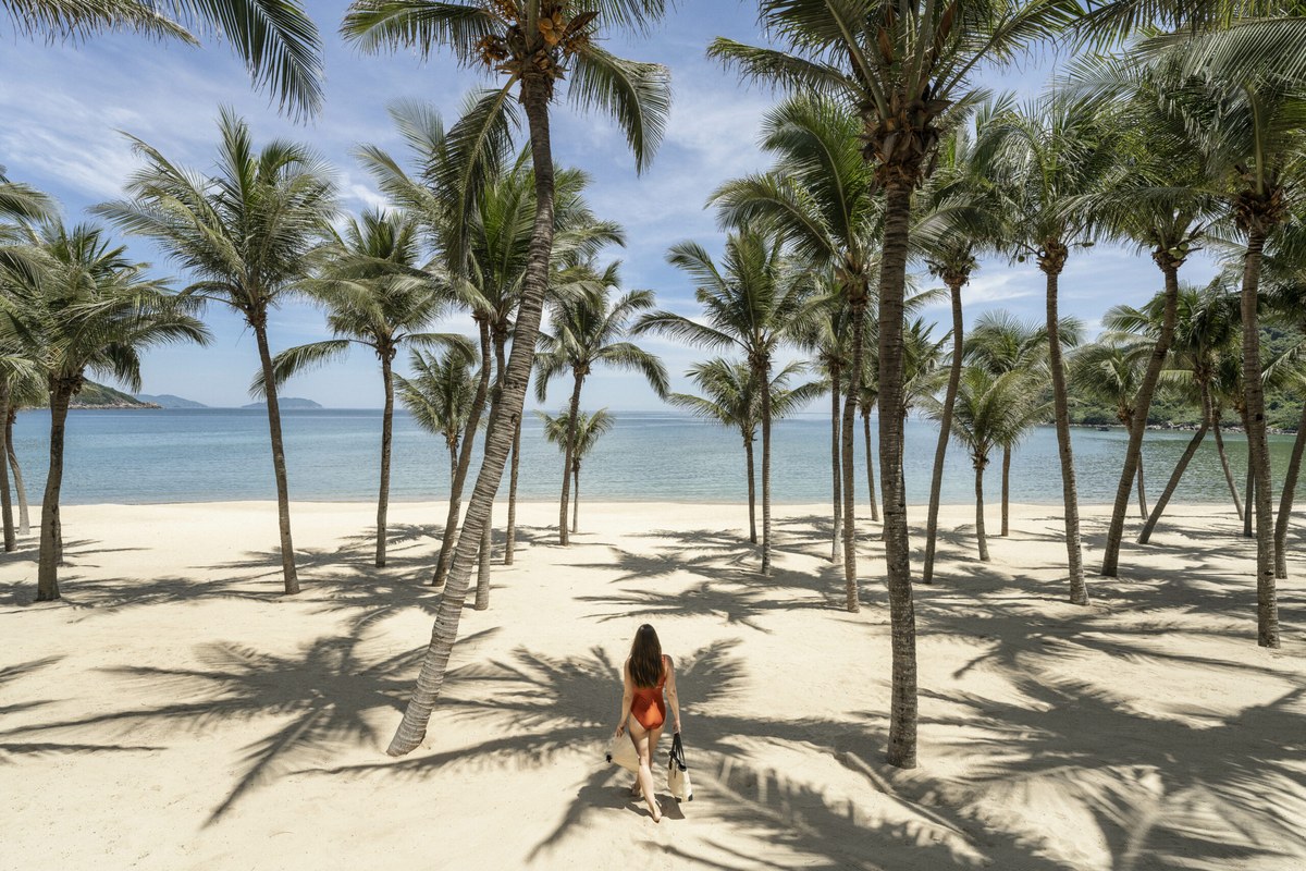 InterContinental Danang Sun Peninsula Resort private beach with palm trees and clear water