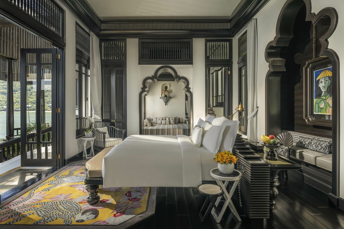 InterContinental Danang Sun Peninsula Resort room interior with dark wood, Moorish arch and yellow carpet