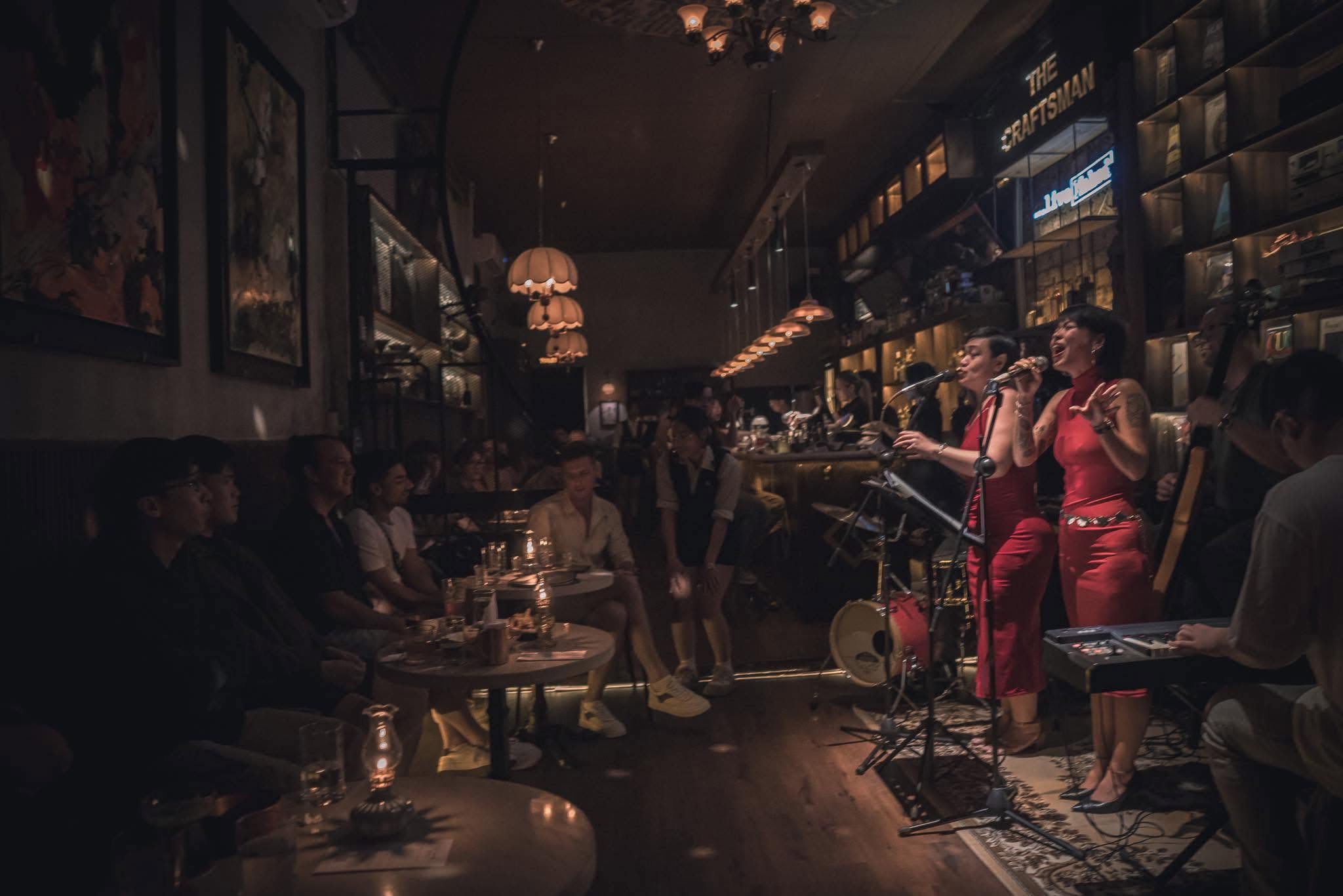 The Craftsman Da Nang — live music night, two singers performing on stage, candlelit house